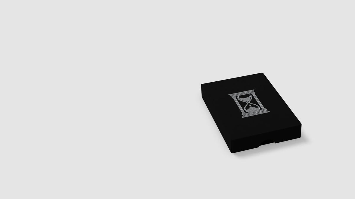 Der Kodex — schwarze Box mit silberner Sanduhr-Prägung, der Deckel hebt sich